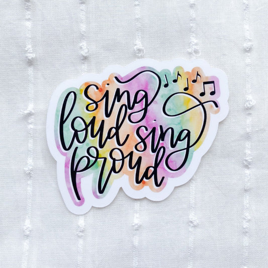 Colorful sticker with 'Sing loud sing proud' text on a textured white background