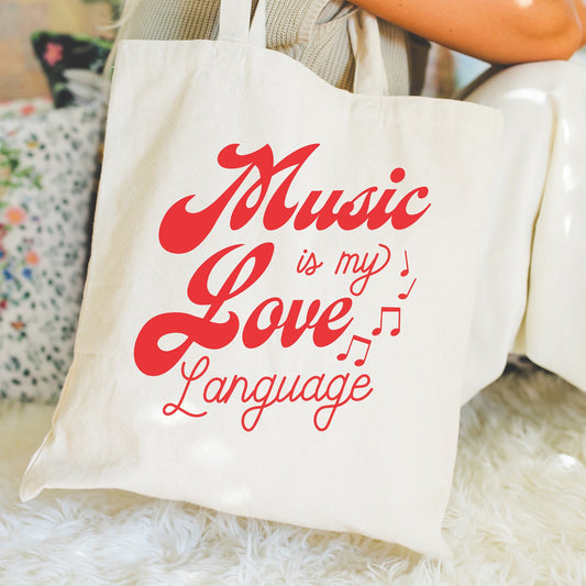 Tote bag with 'Music is my Love Language' text held by a person.
