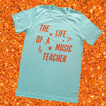 The Life of a Music Teacher Shirt with a background of orange sparkles